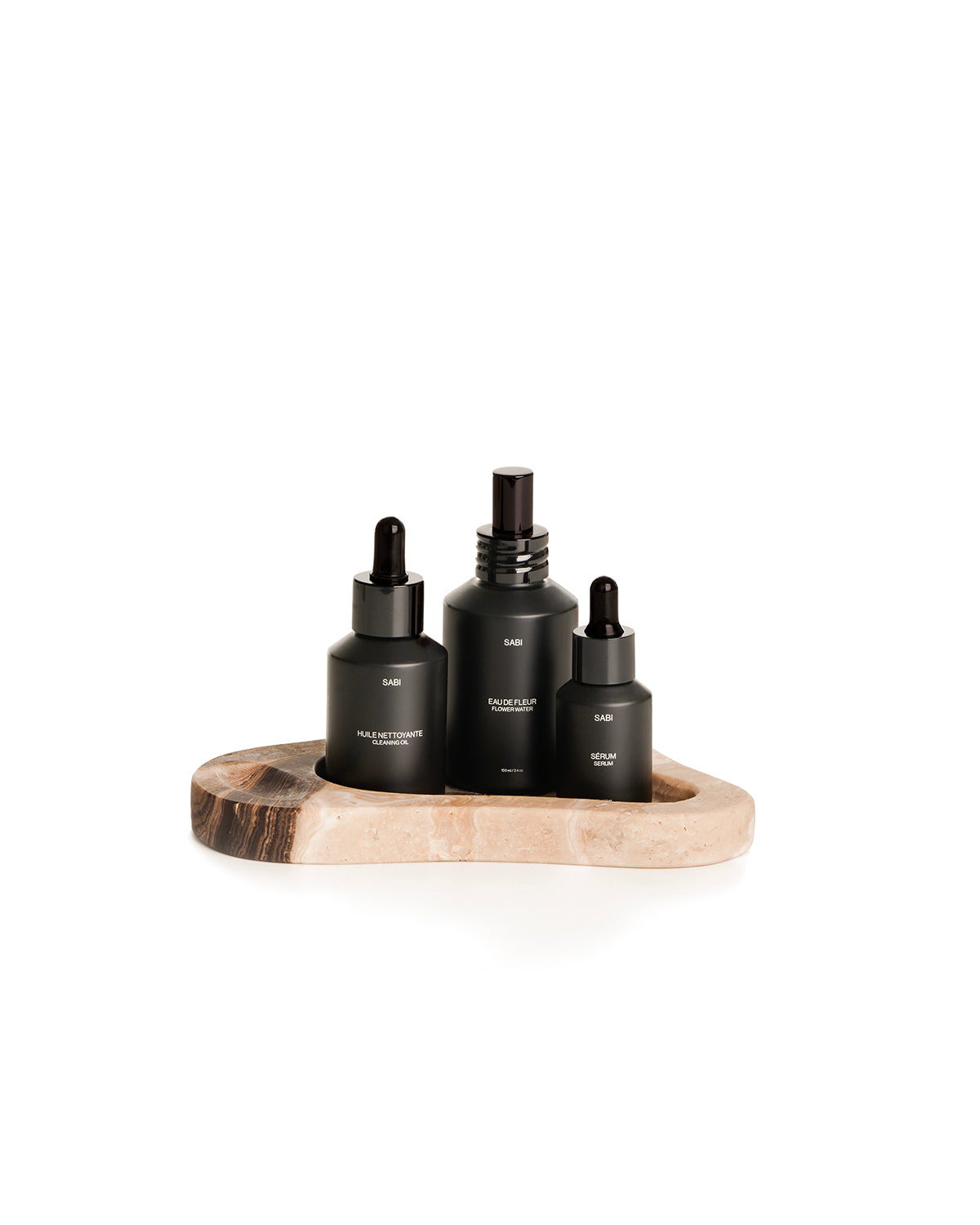 Set of black skincare bottles on a Onyx tray with a white background